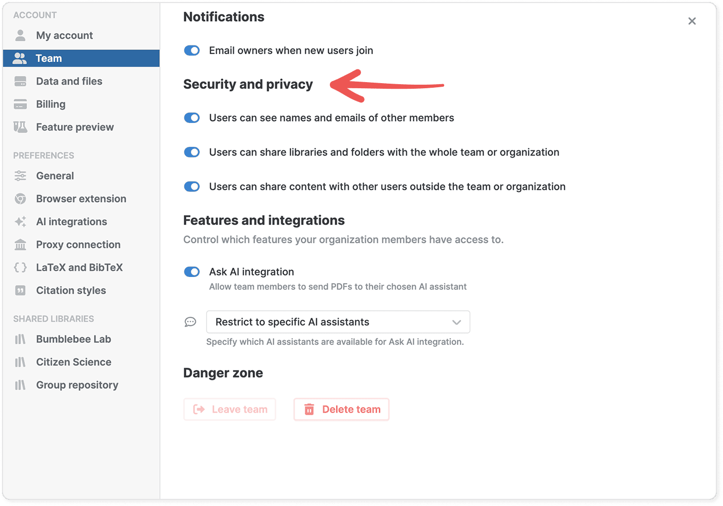 Settings › Team settings with a red arrow pointing to the “Security and privacy” section, whose three toggles control whether members can see other members, share with the whole team, and share outside the organisation.
